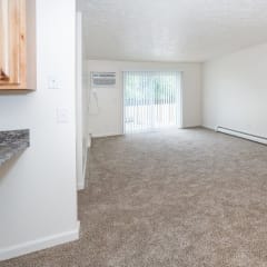 an empty living room with a door to a balcony