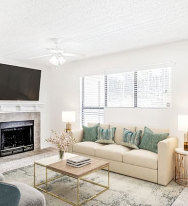 a living room with a fireplace and a tv above it at Bridges at Mallard Creek Apartment Homes, North Carolina