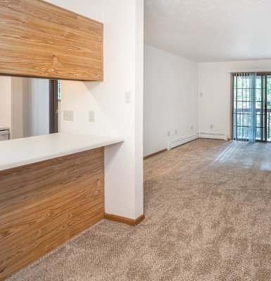 an empty living room with a door leading to a balcony