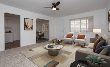 a living room with white walls and a ceiling fan