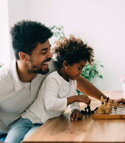 A family playing chess together at a table.