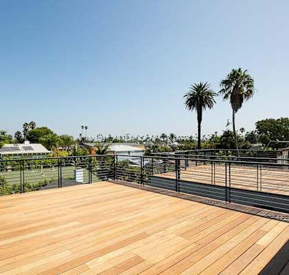 a large wooden deck with a view of a tennis court