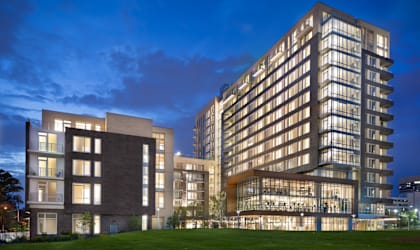 a rendering of a tall building at night with a green field at The Pearl, Silver Spring, MD
