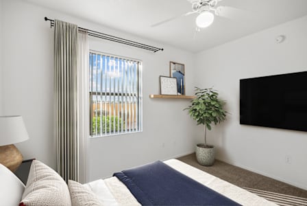 Spacious bedroom with widow and curtain at San Fernando Apartments, Mesa Arizona