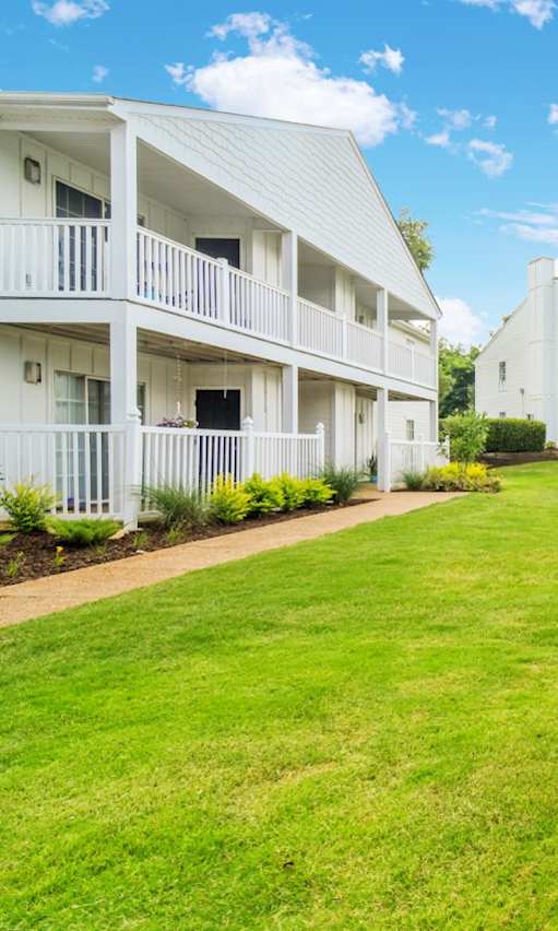 A grassy area in front of apartment buildings.