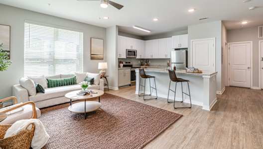 a living room with a couch and a kitchen with a bar