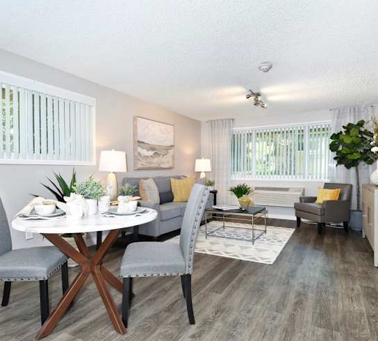 A dining room with a round table and grey chairs.