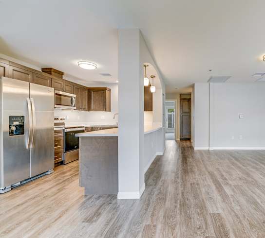 A spacious kitchen with a refrigerator, microwave, and oven.