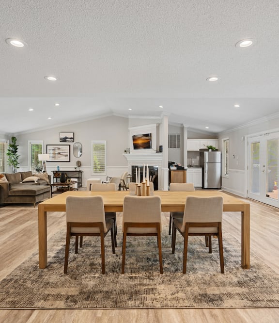 a living room with three mirrors and a wood floor