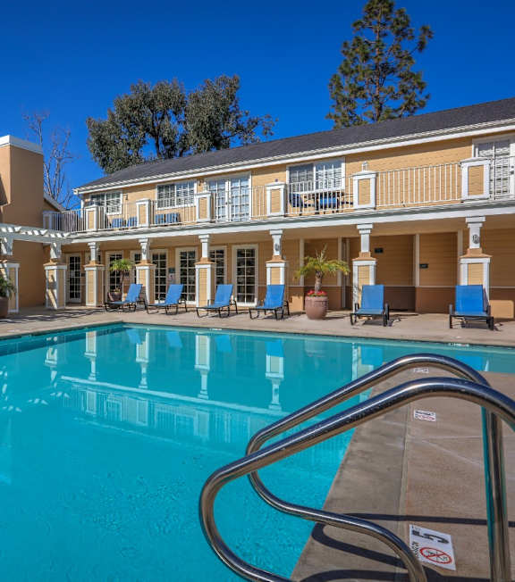 A pool in front of a building with a blue sky in the background at The Villas at Monarch Beach, Dana Point, CA, 92629