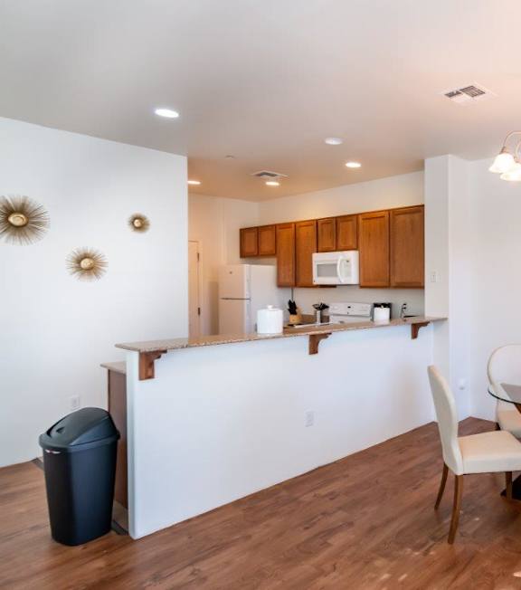 A kitchen with a dining table and chairs.