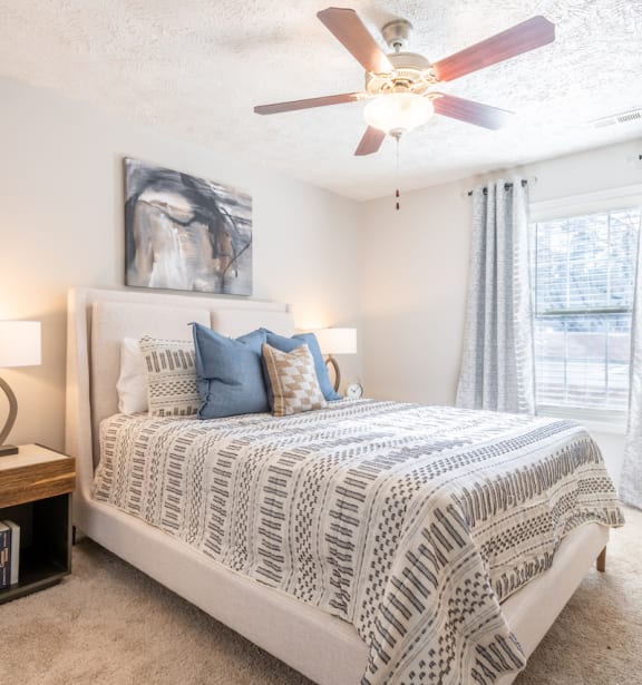 a bedroom with a bed and a ceiling fan