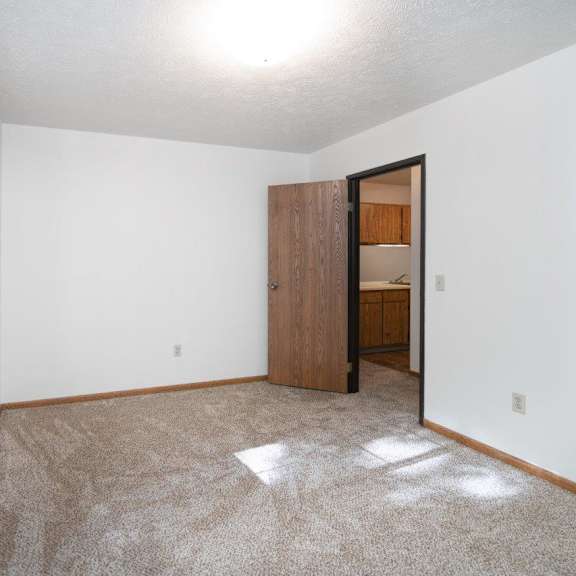 a white bedroom with a large bed and a window