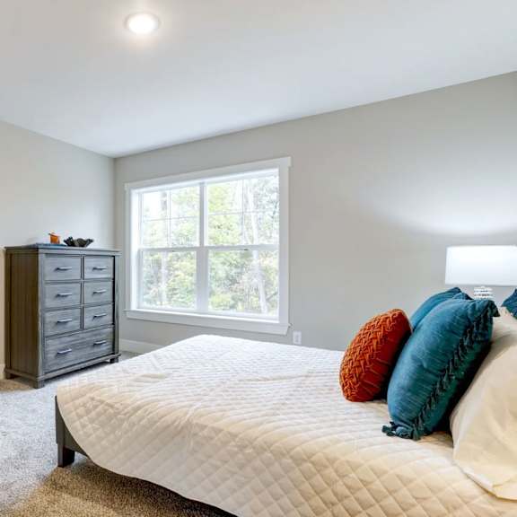 A room with a wooden floor and a kitchenette in the background. at Eden Forest Townhomes Apartments, Kentwood , 49508