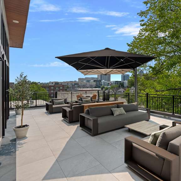 A patio with a black railing and a black umbrella.