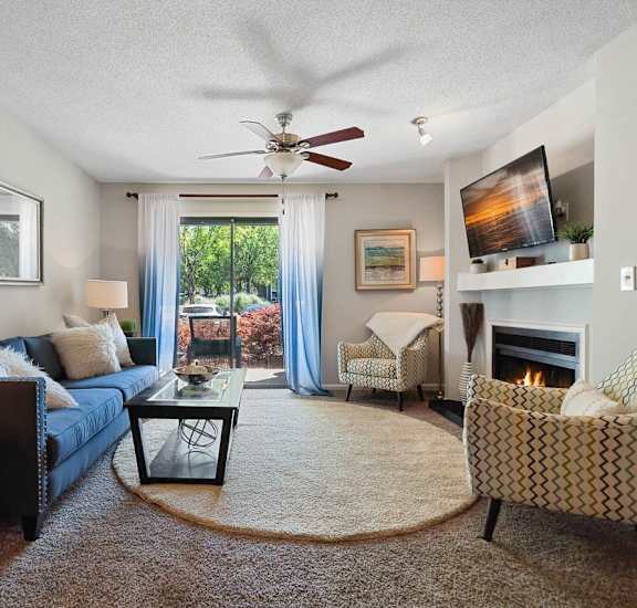 A living room with a couch, chair, and a fireplace.