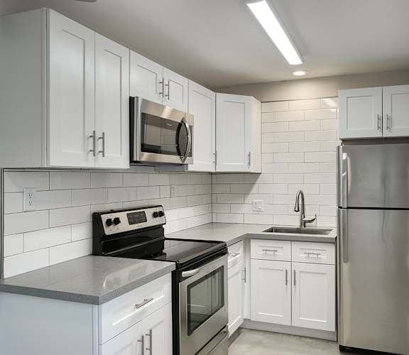 a kitchen with white cabinets and stainless steel appliances