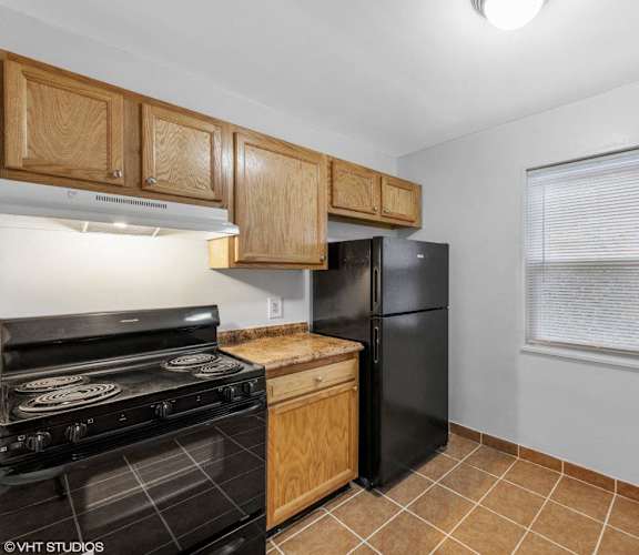 a kitchen with black appliances and wooden cabinets