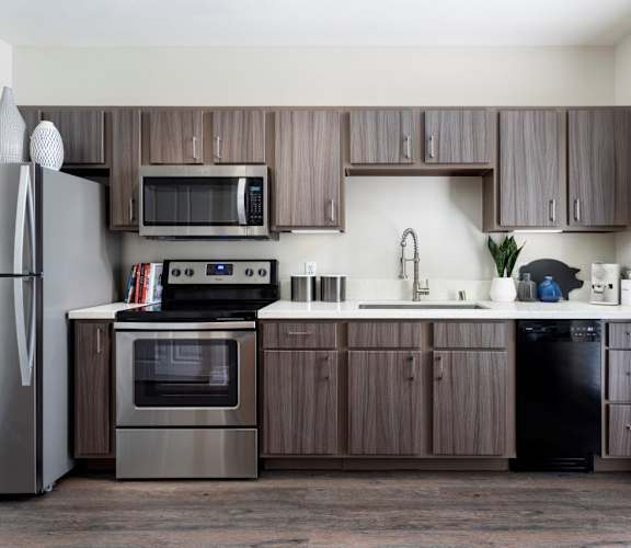 A modern kitchen with dark wood cabinets and stainless steel appliances.