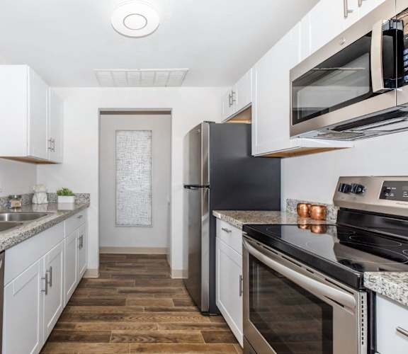 A kitchen with white cabinets and stainless steel appliances.
