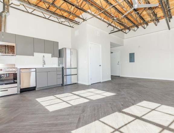 A kitchen with a dining table and a refrigerator.