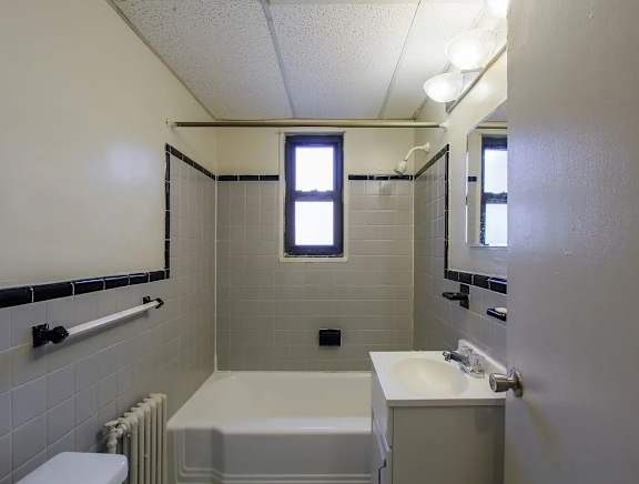 A white bathroom with a tub, toilet, and sink.