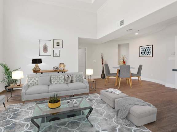 A living room with a grey couch, a glass coffee table, and a grey rug at Toluca Court, Toluca Lake, CA
