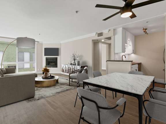 A modern living room with a grey sofa, a round coffee table, and a dining table with chairs.