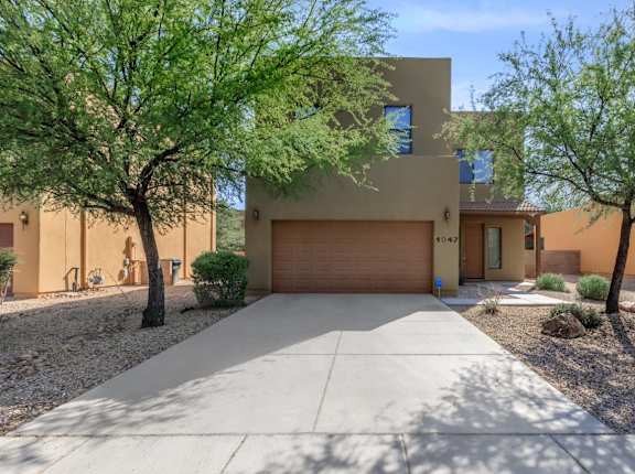 A modern house with a brown garage door and a driveway.