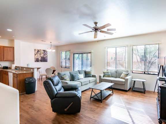 A living room with a black leather chair and a white couch.