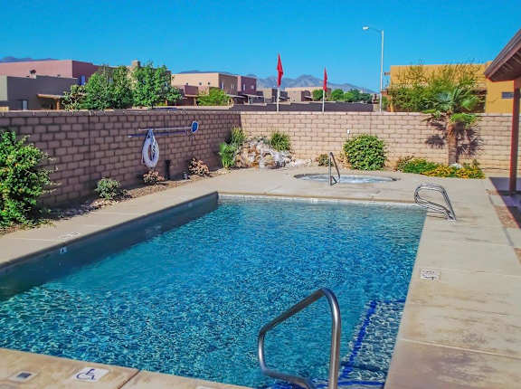 A swimming pool surrounded by a wall and some plants.