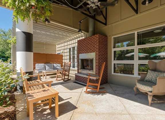 a covered patio with a fireplace and chairs at Village Club of Royal Oak, Royal Oak, 48067