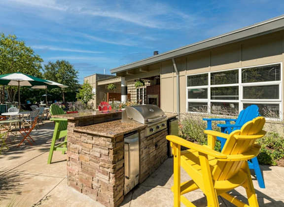 a patio with a barbecue grill and chairs at Village Club of Royal Oak, Royal Oak, 48067