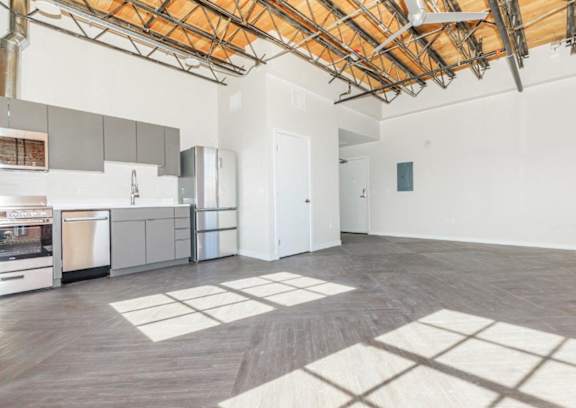 A kitchen with a dining table and a refrigerator.