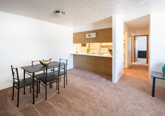 a dining room and kitchen with a table and chairs