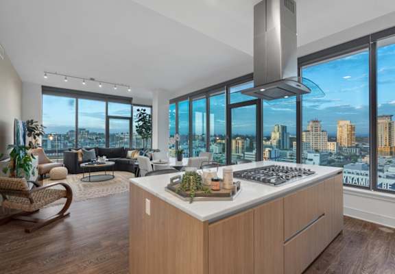 a kitchen with a large island in front of a window with a city view