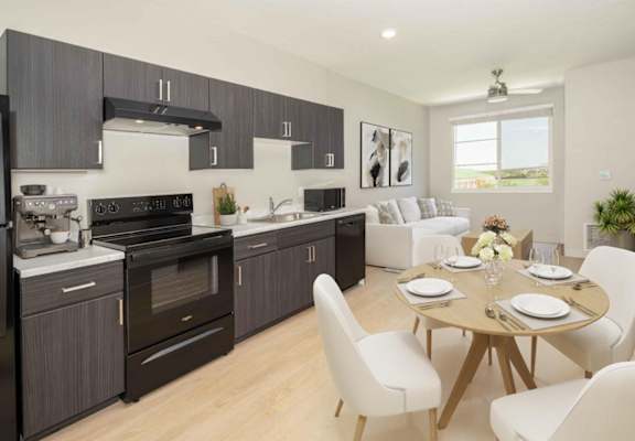 A modern kitchen with a dining table set for two.