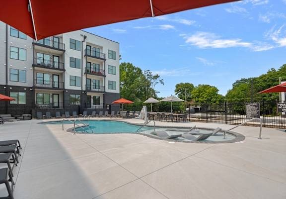 A swimming pool area with a building in the background.