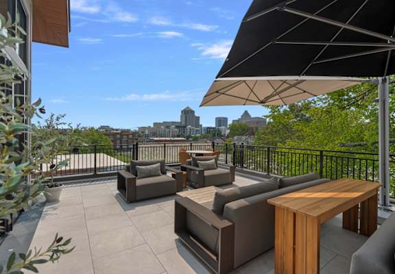 A patio with furniture and a view of the city.