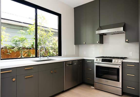a kitchen with a stove top oven next to a window