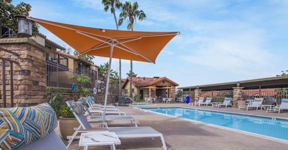 Pool with chairs and umbrellas next to a pool