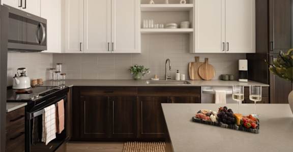 A kitchen with white cabinets and a wooden island.