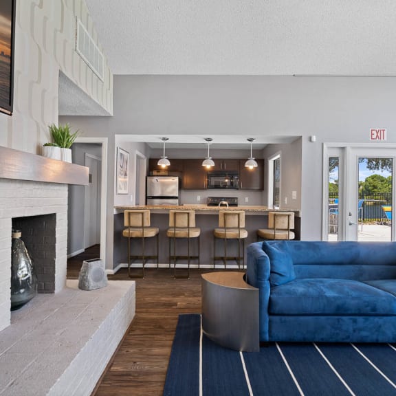 a living room with blue couches and chairs and a fireplace