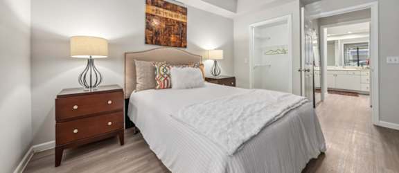 A bedroom with a large bed, a wooden dresser, and a ceiling fan.