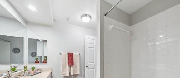 A white bathroom with a white tub and a white sink.