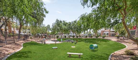 A park with a green lawn and a bench.