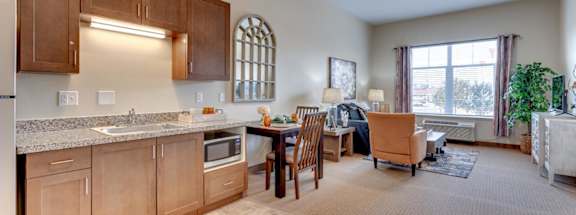 A kitchen with wooden cabinets and a dining table with chairs.