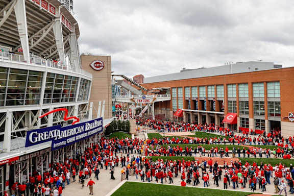 A large crowd of people in red are gathered in front of a building with a sign that reads at Sky Central, Cincinnati, 45202