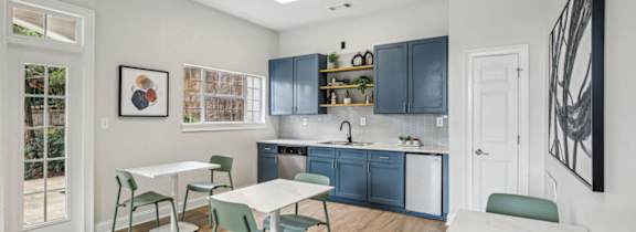 A kitchen with a table and chairs in front of a cabinet.