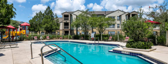 Swimming pool with lounge seating surrounded by native landscaping